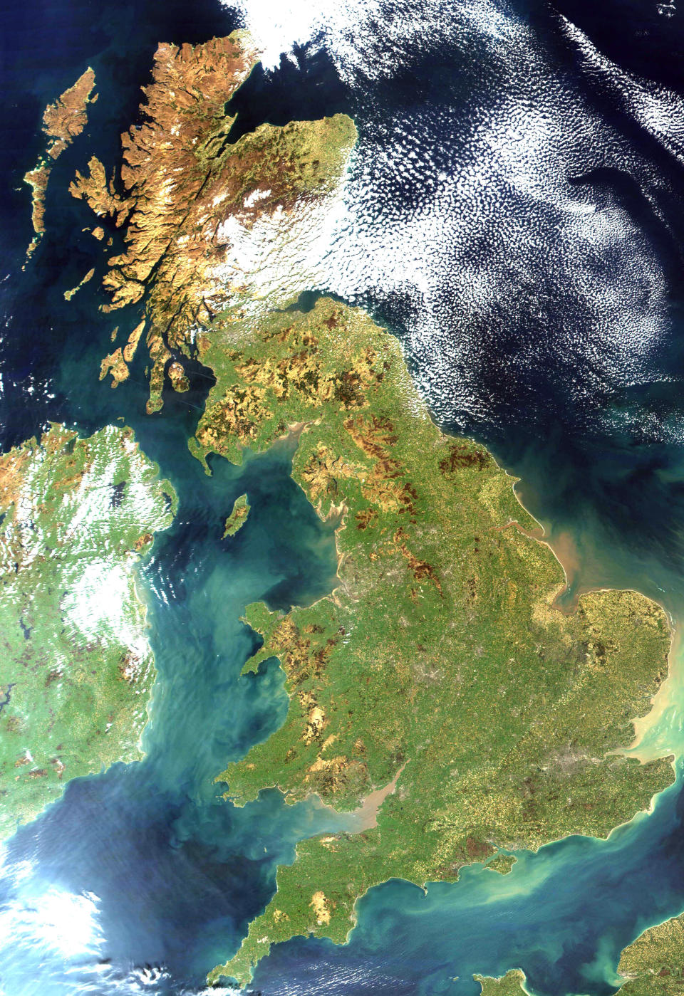 Satellite view of the United Kingdom, showing Scotland, England, and Wales surrounded by water with visible cloud formations overhead