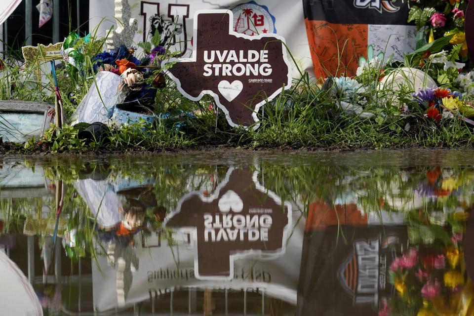 FILE - A make-shift memorial to honor the victims of the shootings at Robb Elementary School is reflected after a recent rain on Aug. 25, 2022, in Uvalde, Texas. Lawmakers in Colorado and other states are proposing bills to roll back legal protections for gun manufactures and dealers. A draft version of Colorado’s bill, expected to be introduced Thursday, Feb. 23, 2023 would make it easier for Colorado residents to sue gun manufacturers and lays out a code of conduct for the industry partly targeting how companies design and market firearms. (AP Photo/Eric Gay, File)