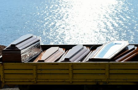 Coffins are seen as emergency services carry bodies from a migrant shipwreck that took place on October 7 back to the island of Lampedusa