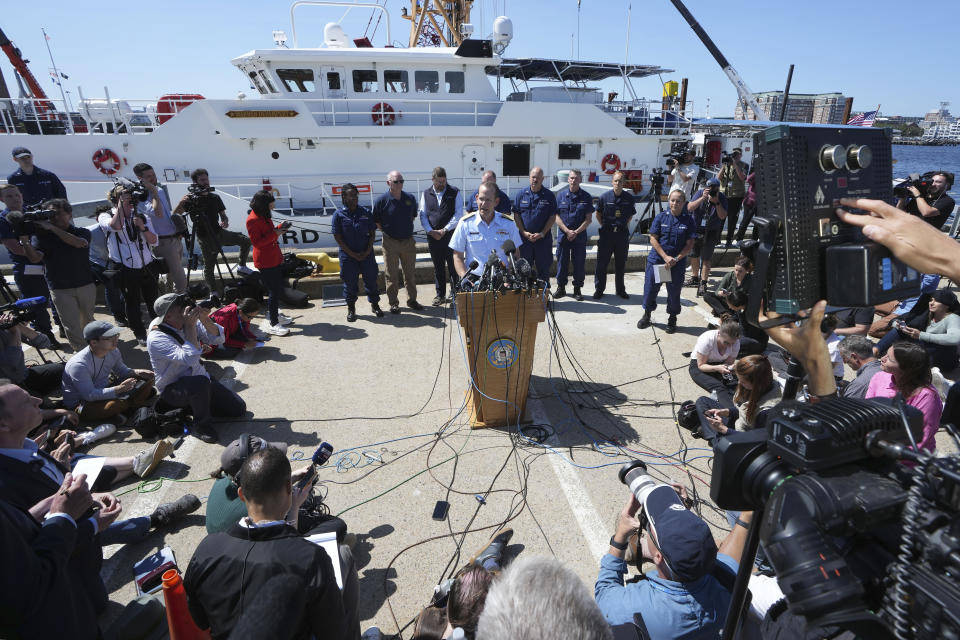 U.S. Coast Guard Rear Adm. John Mauger, commander of the First Coast Guard District, center at microphone, talks to the media Thursday, June 22, 2023, at Coast Guard Base Boston, in Boston. The U.S. Coast Guard says the missing submersible imploded near the wreckage of the Titanic, killing all five people on board. Coast Guard officials said during the news conference that they've notified the families of the crew of the Titan, which has been missing for several days. (AP Photo/Steven Senne)