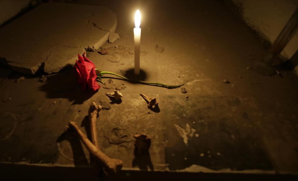 A candle burns inside an empty mausoleum at El Tejar cemetery, in downtown Quito, Ecuador, Wednesday, Sept. 11, 2019. On a recent evening, 13 visitors ventured into the cemetery, which is filled with blocks of tombs stacked four levels and higher. (AP Photo/Dolores Ochoa)