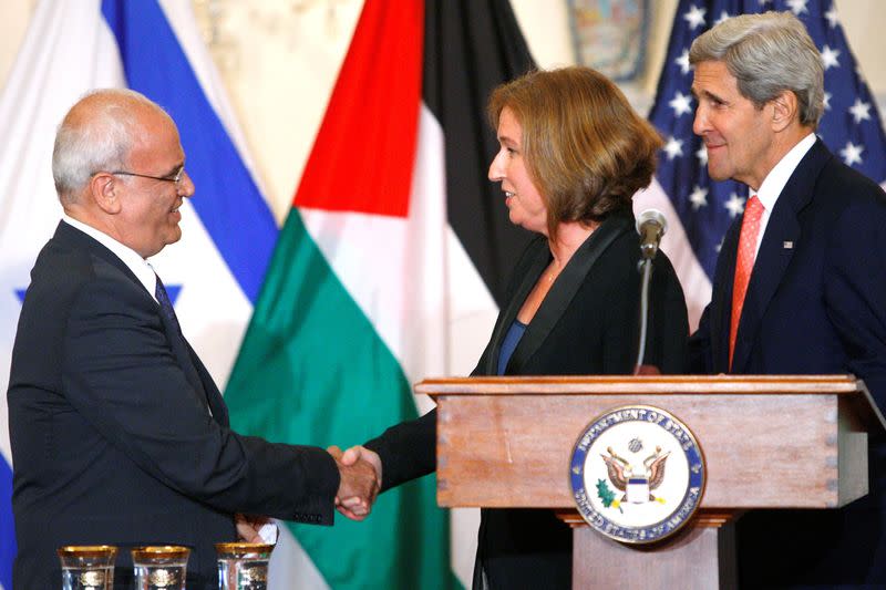 FILE PHOTO: Chief Palestinian negotiator Saeb Erekat shakes hands with Israel's Justice Minister Tzipi Livni near U.S. Secretary of State John Kerry after announcing further talks at a news conference in Washington