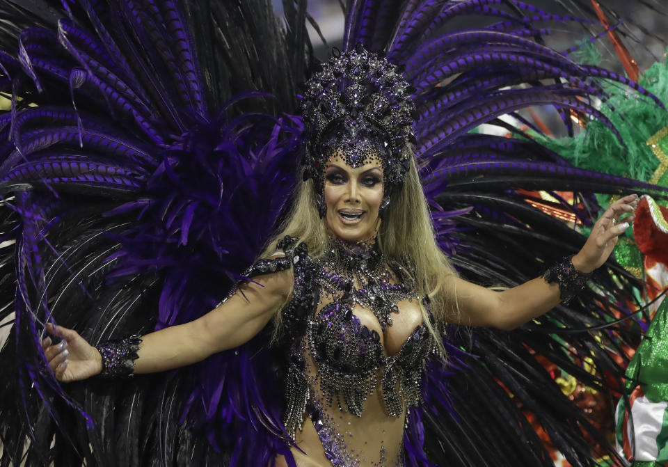 Transgender godmother Camila Prins, representing the Colorado do Bras samba school, performs at Carnival in the Sambadrome in Sao Paulo, Brazil, Saturday, Feb. 22, 2020. Prins entered the parade grounds, in a costume of feathers that displayed her sinuous body, fulfilling a dream nearly three decades old. (AP Photo/Andre Penner)