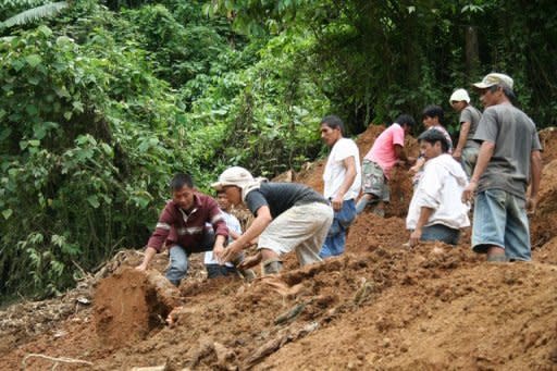 Philippine rescuers claw through dirt in search for survivors a day after a landslide buried workers in mining tunnels in a gold-rich southern Philippines area in Kingking village of Pantukan town, Compostela province. Philippine officials say there is little chance of finding more survivors, with 22 people likely killed in the disaster