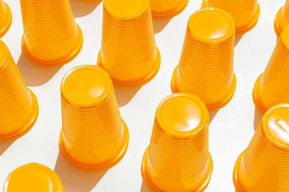 Multiple orange plastic cups arranged on a surface