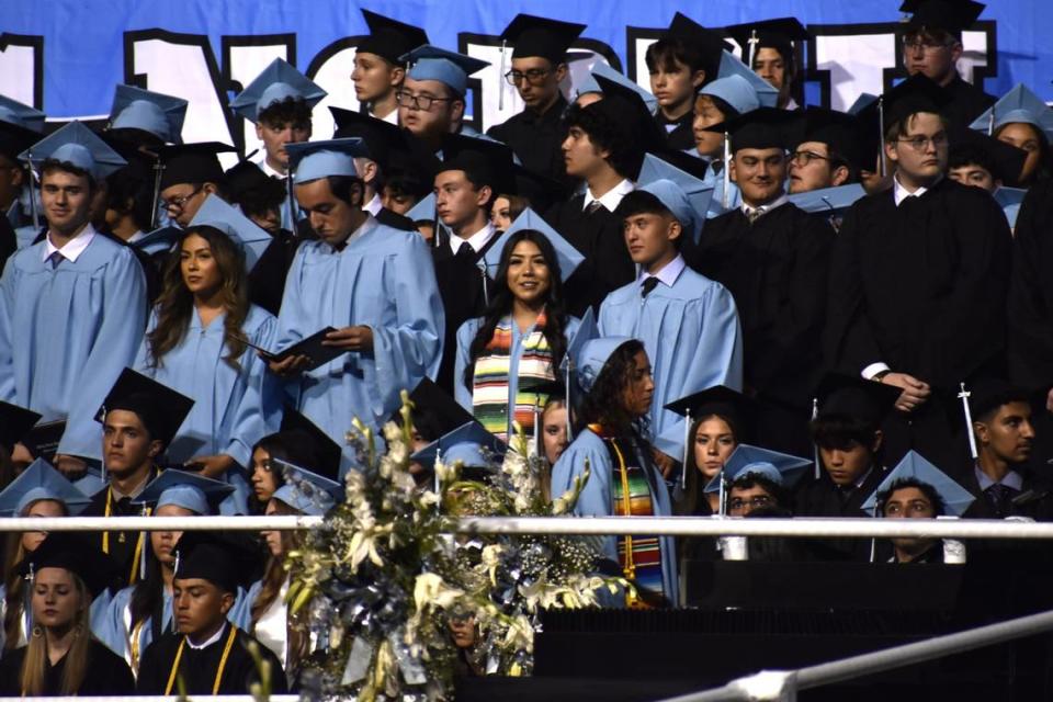 Camila Lemus (centro) sonríe mientras está de pie con sus compañeros de clase después de recibir su diploma y graduarse de Clovis North High School, la noche del martes 4 de junio de 2024. La joven de 17 años tenía dos empleos mientras estudiaba a tiempo completo y era miembro fundador del Latino Club de la escuela y del grupo de baile folclórico Las Caballeras del Norte.