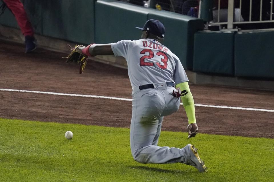 St. Louis Cardinals' Marcell Ozuna can't catch a ball hit by Washington Nationals' Anthony Rendon during the third inning of Game 3 of the baseball National League Championship Series Monday, Oct. 14, 2019, in Washington. Adam Eaton scored on the play. (AP Photo/Alex Brandon)