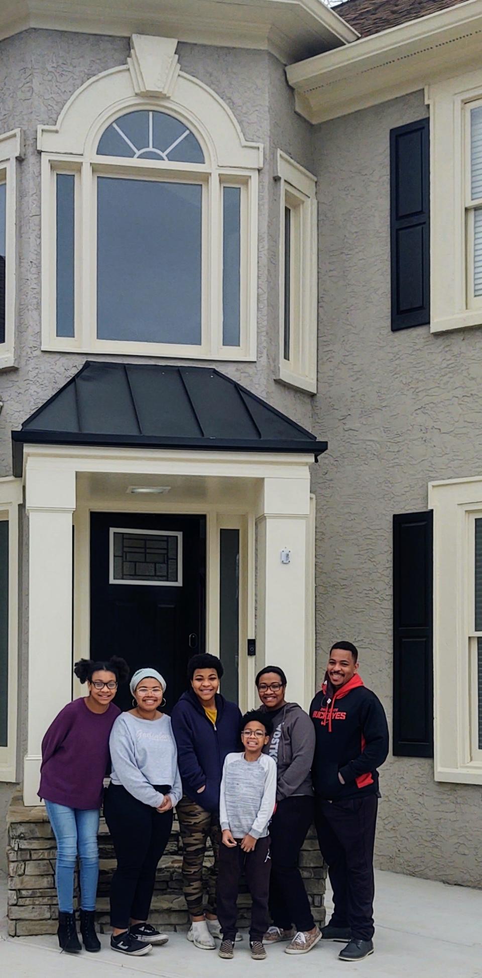 William Thomas and his family pose outside their new home in Woodstock, Georgia. He both bought and sold a home during the pandemic.