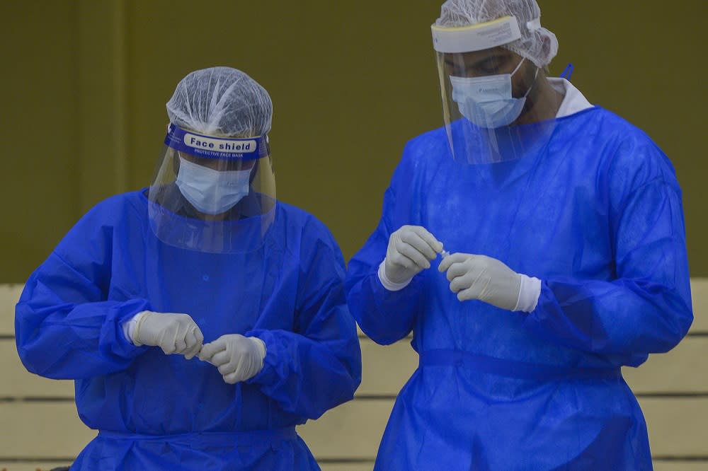 Health workers in protective suits collect swab samples to test for Covid-19 in Petaling Jaya January 18, 2021. —  Picture by Miera Zulyana