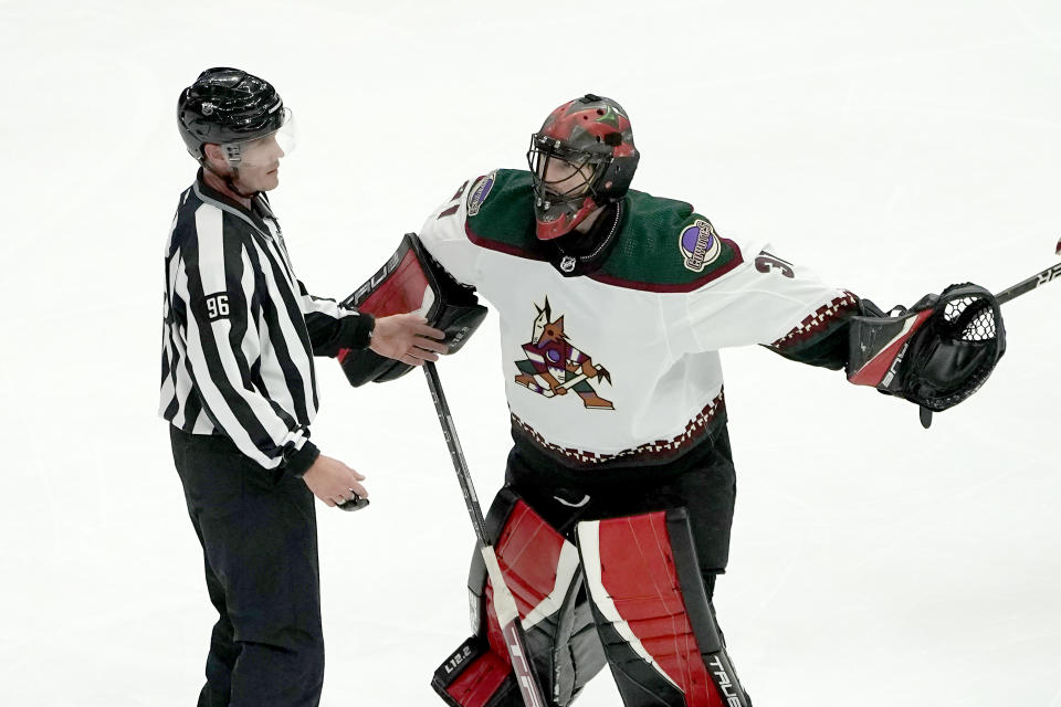 Arizona Coyotes goalie Scott Wedgewood confronts linesman David Brisebois (96) during the second period of an NHL hockey game Chicago Blackhawks Friday, Nov. 12, 2021, in Chicago. (AP Photo/Charles Rex Arbogast)