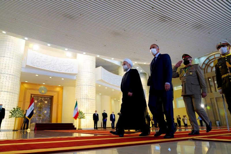 FILE PHOTO: Iranian President Hassan Rouhani welcomes Iraqi Prime Minister Mustafa al-Kadhimi as they wear protective masks, in Tehran