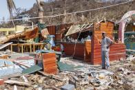 A man stands next to a business destroyed by Hurricane Beryl in Clifton, Union Island, St. Vincent and the Grenadines, Thursday, July 4, 2024. (AP Photo/Lucanus Ollivierre)