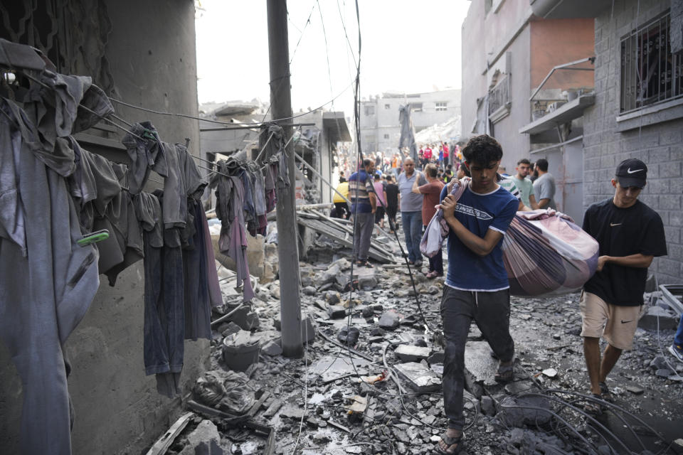 Palestinians carry a body after the Israeli bombardment in the Maghazi refugee camp in the Gaza Strip on Sunday, Nov. 5, 2023. (AP Photo/Hatem Moussa)