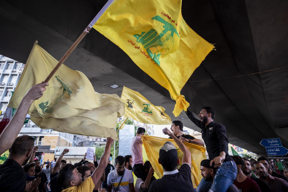 Hezbollah and Amal supporters wave Hezbollah and Iranian flags as they shout slogans against Israel and U.S. during a protest in the southern suburb of Beirut, Lebanon, Sunday, June 28, 2020. The protest came hours after Lebanon's foreign minister summoned the U.S. ambassador to Beirut over comments, she made recently in which she criticized Hezbollah. The meeting between Foreign Minister Nassif Hitti and Ambassador Dorothy Shea is scheduled for Monday afternoon. (AP Photo/Hassan Ammar)