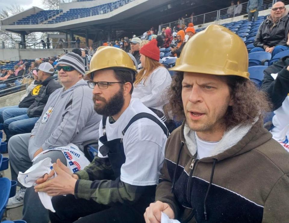 Matt Hampton, right, of Alliance, and Alex Hampton, of Atwater, second from right, cheer on the Pittsburgh Maulers on Sunday at the USFL's regular season opener at Tom Benson Hall of Fame Stadium in Canton.