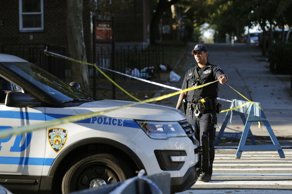 Emergency personnel work near the scene of a fatal shooting of a police officer in the Bronx borough of New York, Sunday, Sept. 29, 2019. (AP Photo/Seth Wenig)