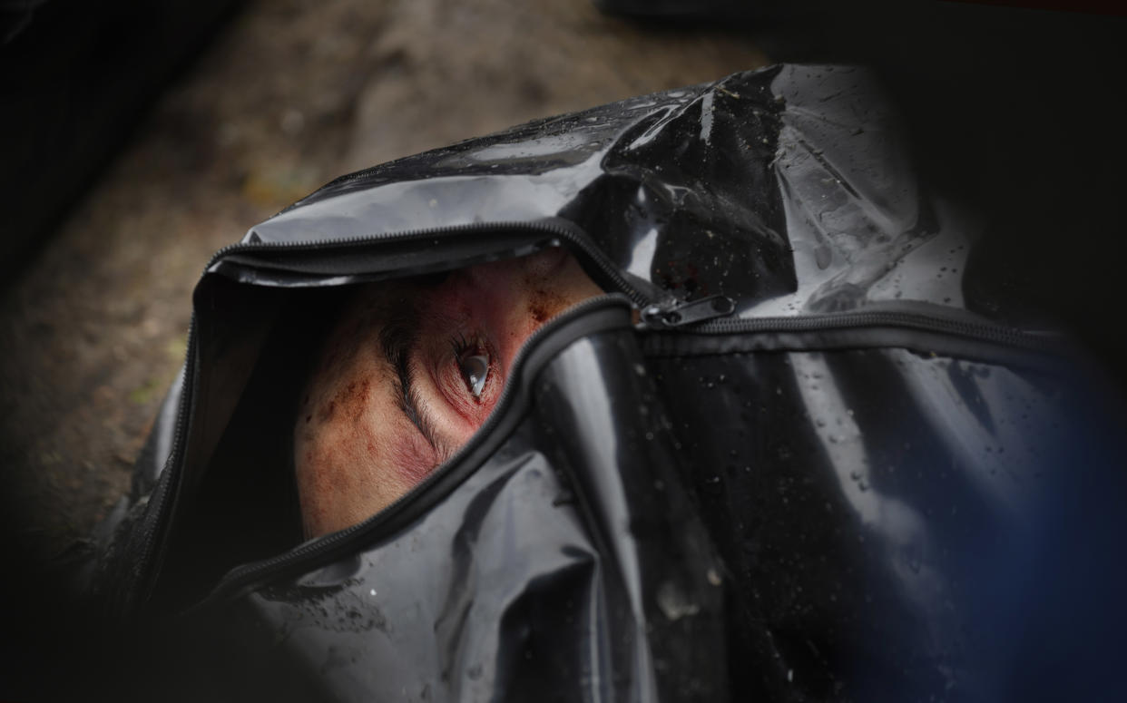 A corpse lies in a body bag as investigators begin chronicling civilian deaths in Bucha. 