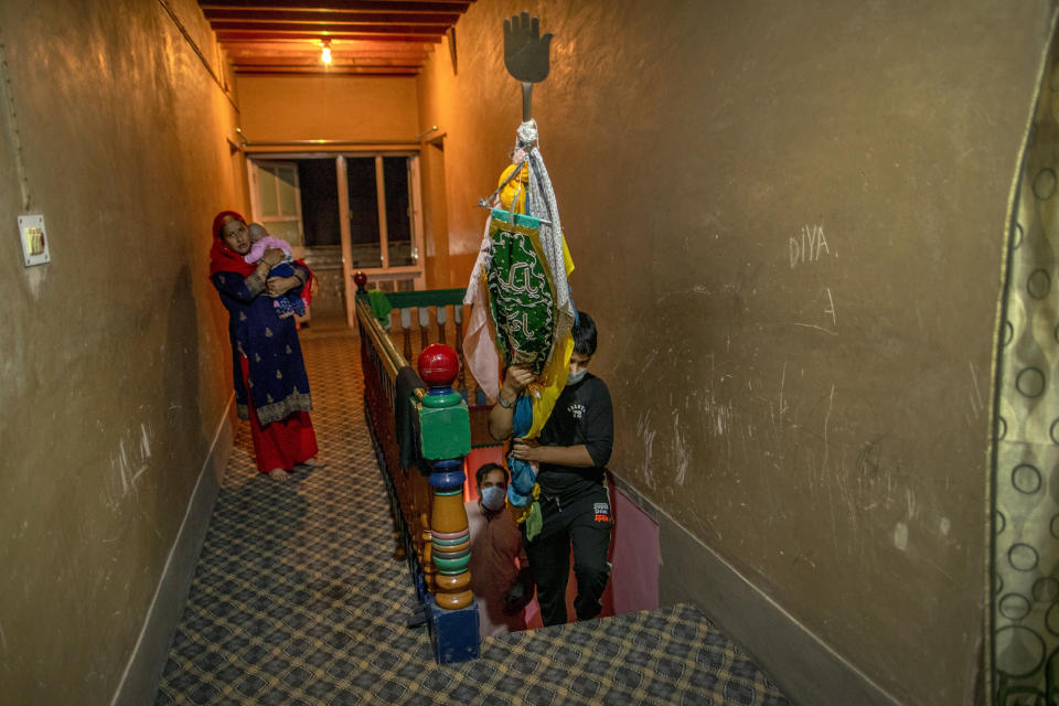 A Kashmiri Shiite Muslim boy brings back religious flag to his home after taking part in commemoration of Muharram in Srinagar Indian-controlled Kashmir, Friday, Aug. 21, 2020. Observing the Muslim month of Muharram, which marks the martyrdom of the Prophet Muhammad’s grandson in the battle of Karbala, is an article of faith. But as the coronavirus spreads in Indian-controlled Kashmir, Shiite Muslims prefer to commemorate the holy days inside their home following the advice of religious scholars and health experts in the disputed region’s main city. (AP Photo/Dar Yasin)