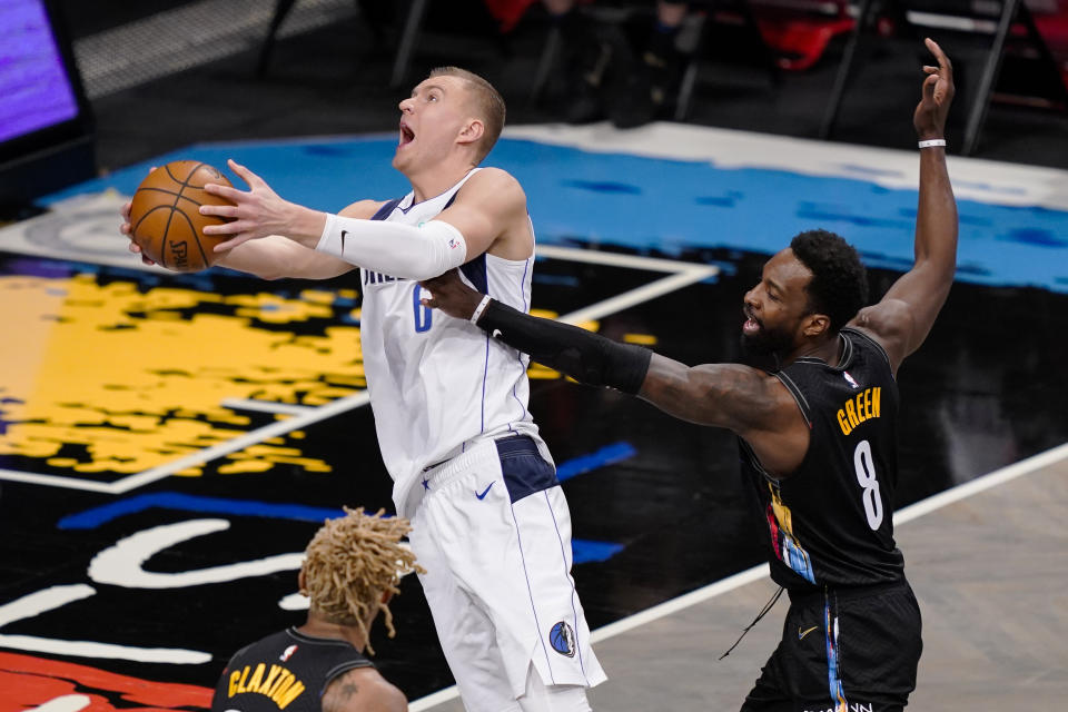 Dallas Mavericks center Kristaps Porzingis (6) shoots against Brooklyn Nets forward Jeff Green (8) during the second half of an NBA basketball game Saturday, Feb. 27, 2021, in New York. (AP Photo/John Minchillo)