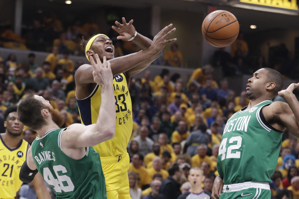 Indiana Pacers center Myles Turner (33) is fouled as he shoots between Boston Celtics' Aron Baynes (46) and Al Horford (42) during the first half of Game 3 of an NBA basketball first-round playoff series Friday, April 19, 2019, in Indianapolis. (AP Photo/Darron Cummings)