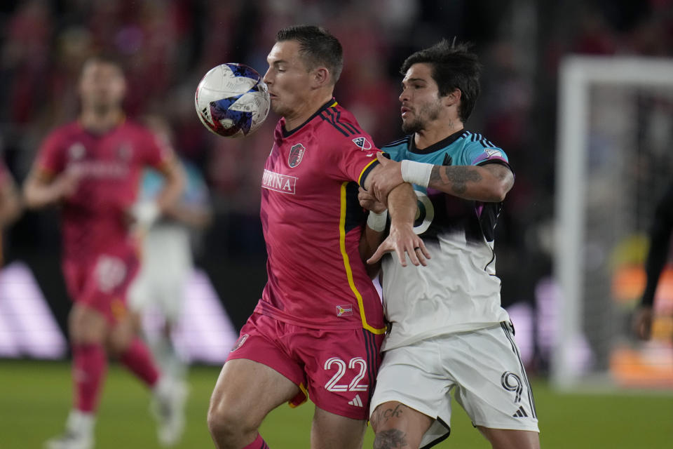 St. Louis City's Kyle Hiebert (22) and Minnesota United's Luis Amarilla battle for the ball during the first half of an MLS soccer match Saturday, April 1, 2023, in St. Louis. (AP Photo/Jeff Roberson)