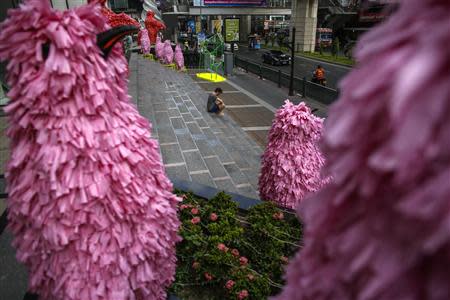 A tourist sits on a stair in front of a department store in central Bangkok December 16, 2013. REUTERS/Athit Perawongmetha