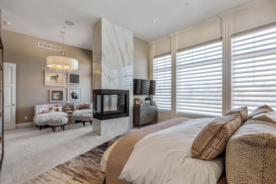 A three-sided Italian marble fireplace anchors the master bedroom.