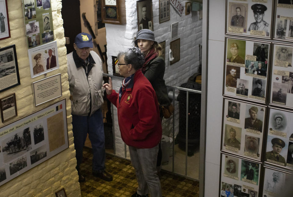 In this photo taken on Tuesday, Dec. 10, 2019, Mathilde Schmetz takes U.S. Battle of the Bulge veteran Arthur Jacobson, left, through the Remember Museum 39-45 in Thimister-Clermont, Belgium. In the bucolic, verdant hills which were once among the worst killing grounds of WWII Marcel and Mathilde Schmetz have shared coffee and cake with countless veterans, telling stories that span generations. Veterans of the WWII Battle of the Bulge are heading back to mark, perhaps the greatest battle in U.S. military history, when 75-years ago Hitler launched a desperate attack deep through the front lines in Belgium and Luxembourg to be thwarted by U.S. forces. (AP Photo/Virginia Mayo)