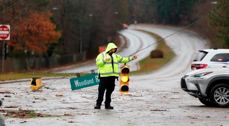 Garner police direct traffic off Timber Drive at Woodland Road after a storm knocked down limbs and traffic lights in Garner, N.C., Sunday, Dec. 10, 2023.