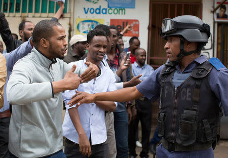 Somali nationals argue with police during clashes in Pretoria, South Africa, February 24, 2017. Police fired tear gas, water cannon and rubber bullets to disperse rival marches by hundreds of protesters in Pretoria on Friday, after mobs looted stores this week believed to belong to immigrants. REUTERS/ James Oatway.