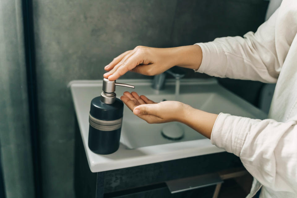 a person using hand soap in a bathroom