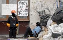 Masked pro-Russian activists guard a barricade at the regional administration building that they had seized earlier in Donetsk, Ukraine, Saturday, April 19, 2014. Pro-Russian insurgents defiantly refused Friday to surrender their weapons or give up government buildings in eastern Ukraine, despite a diplomatic accord reached in Geneva and overtures from the government in Kiev. (AP Photo/Efrem Lukatsky)