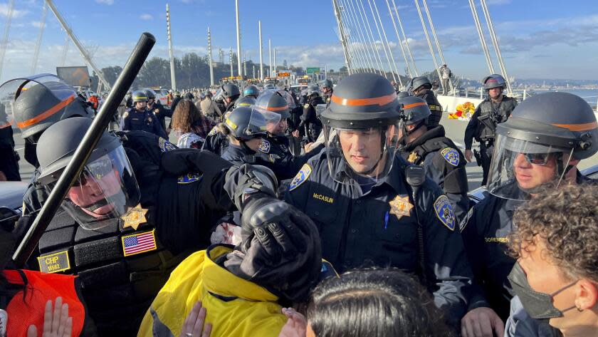 Police officers clear demonstrators blocking the San Francisco-Oakland Bay Bridge while protesting against the APEC summit on Thursday, Nov. 16, 2023, in San Francisco. (AP Photo/Noah Berger)