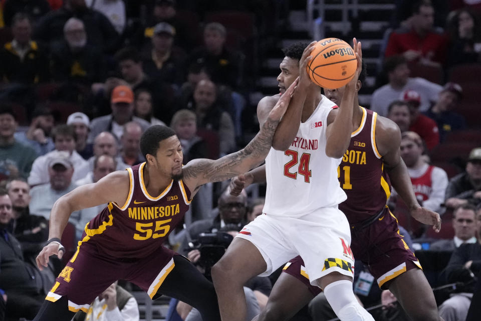 Maryland's Donta Scott (24) looks to pass under pressure from Minnesota's Ta'lon Cooper during the first half of an NCAA college basketball game at the Big Ten men's tournament, Thursday, March 9, 2023, in Chicago. (AP Photo/Charles Rex Arbogast)