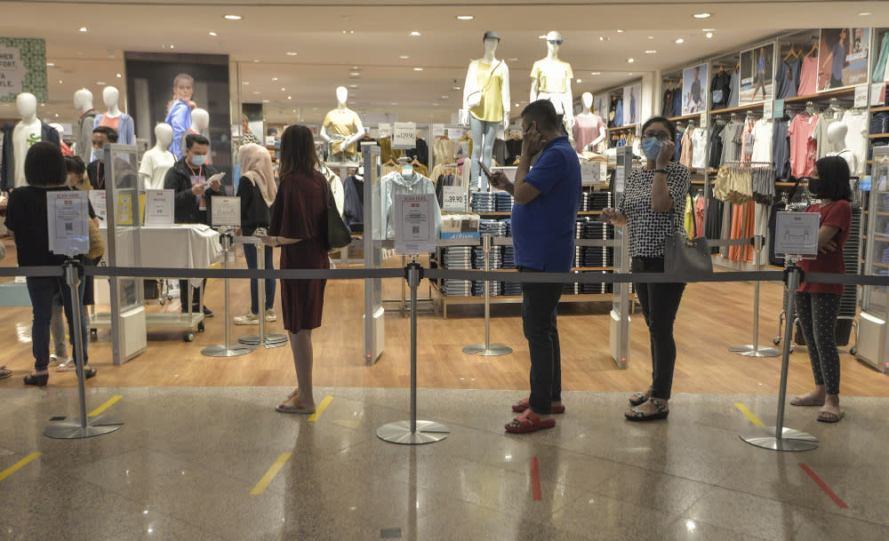 Shoppers line up at one of the stores at one of the shopping malls in Kuala Lumpur, May 26, 2020 — Picture by Shafwan Zaidon