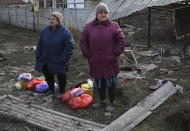 Local women stand after receiving food at a mobile humanitarian aid point in the village of Zarichne, Donetsk region, Ukraine, Friday, Dec. 2, 2022. (AP Photo/Andriy Andriyenko)