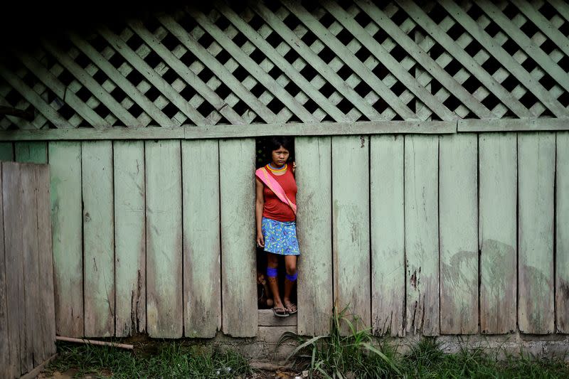 Una mujer indígena observa a la gente fuera de un refugio para enfermos en la unidad sanitaria del Centro de Base de Auaris, en la tierra indígena yanomami, estado de Roraima