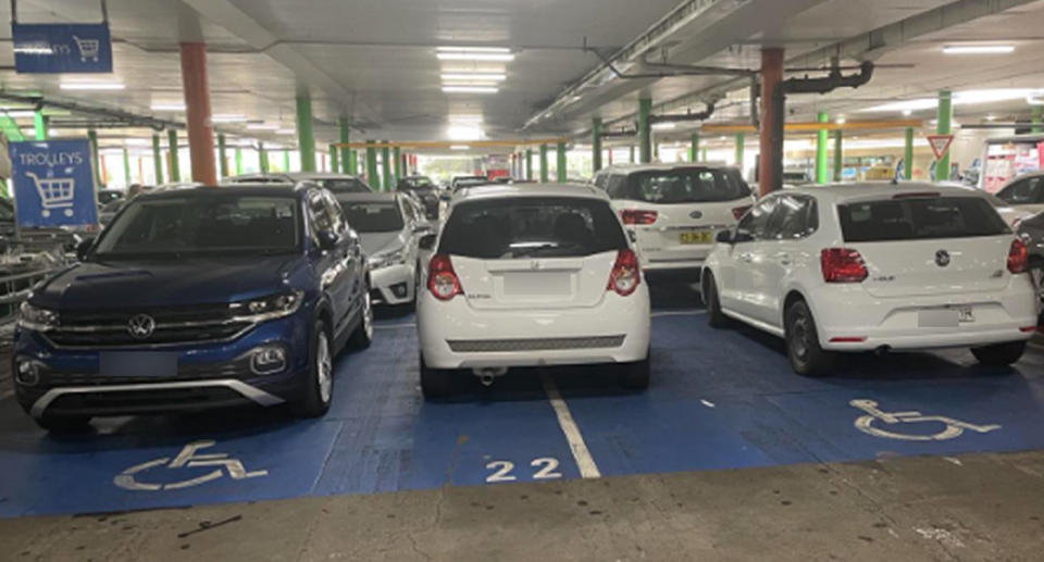 A photo taken at Campbelltown Mall shows a car squeezed in between two cars in the disabled parking bays.