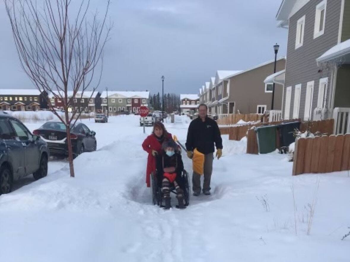 Ruth Fitzsimmons tries to get down a Whitehorse sidewalk with the help of her children, Don and Beverley. Her daughter, Helen, says residents need to shovel the sidewalks in front of their homes. (Helen Fitzsimmons - image credit)