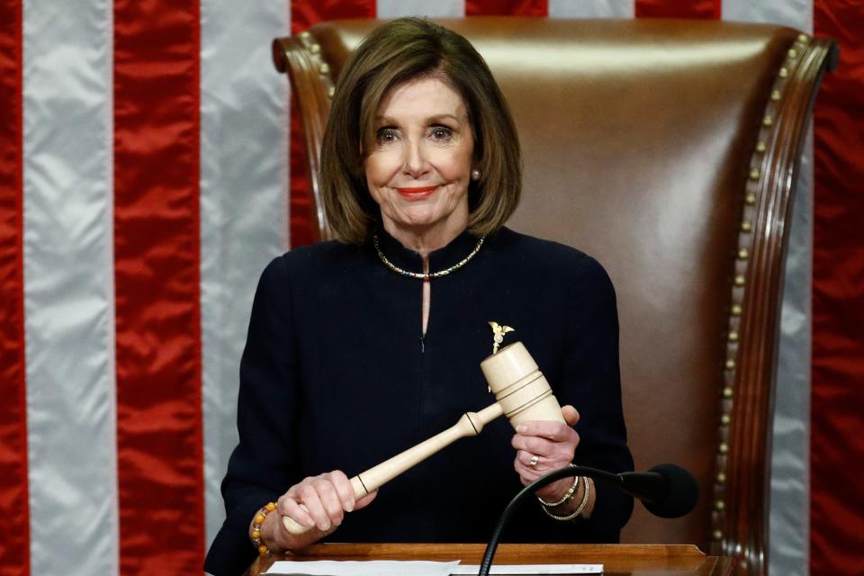 House Speaker Nancy Pelosi of California smiles as she holds the gavel as the House votes on articles of impeachment against President Donald Trump on Dec. 18, 2019.