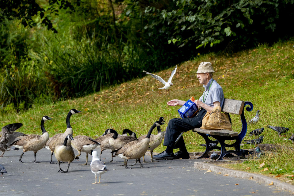 <p>A man feeds the birds by the lake at Sefton Park, in Liverpool, as the warm weather there continues. Homes, roads and Tube stations have been flooded while two London hospitals asked patients to stay away after thunderstorms battered the south of England on Sunday.</p>
