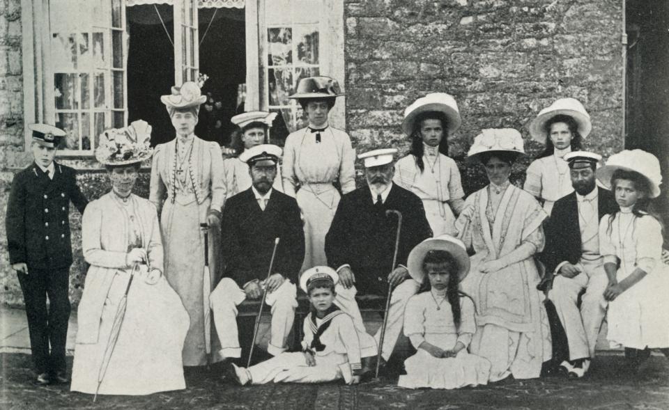 The British and Russian royal families, 1909, (1951). 'An official photograph to mark the visit to this country in 1909 of the late Czar and Czarina of Russia, their four daughters and the young Czarevich. With them in the picture are King Edward VII and Queen Alexandra, King George V and Queen Mary, the Prince of Wales and the Princess Royal'. Portrait taken at Barton Manor, Isle of Wight on 4 August 1909, of Tsar Nicholas II and Tsarina Alexandra of Russia with their children Olga, Tatiana, Maria, Anastasia and Alexei; King Edward VII and Queen Alexandra with the future King George V (first cousin of the Tsar), Mary of Teck, the Prince of Wales (future King George VI) and Mary, Princess Royal. The Russian royal family were executed in 1918 by Bolshevik guards. From 