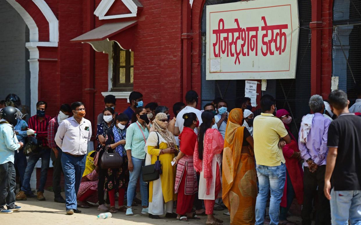 People stand in queues as they wait to register themselves for the Covid-19 coronavirus test at a testing centre - AFP