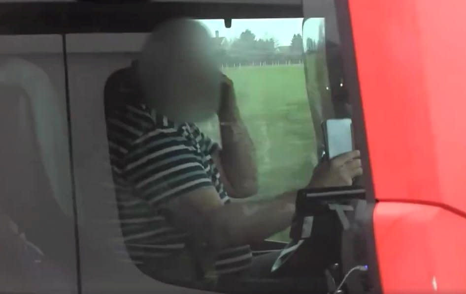 This is the moment police caught a lorry driver on the motorway holding two mobile phones - one to each ear. See SWNS story SWBRears; The footage was captured during Operation Tramline - and shows the trucker on the M4 motorway in his 44 tonne articulated lorry. Avon and Somerset Police were using a large goods vehicle (LGV) - allowing roads policing officers to gain an elevated view. The officers can be seen pulling alongside the lorry driver, who quickly removes the phones from his ears to put both hands back on the steering wheel. The offending vehicle was then reported to a supporting policing unit which intercepted, indicated for it to pull over and dealt with offences. Chief Inspector Jason Shears, Roads Policing Lead for Avon and Somerset Police, said: 