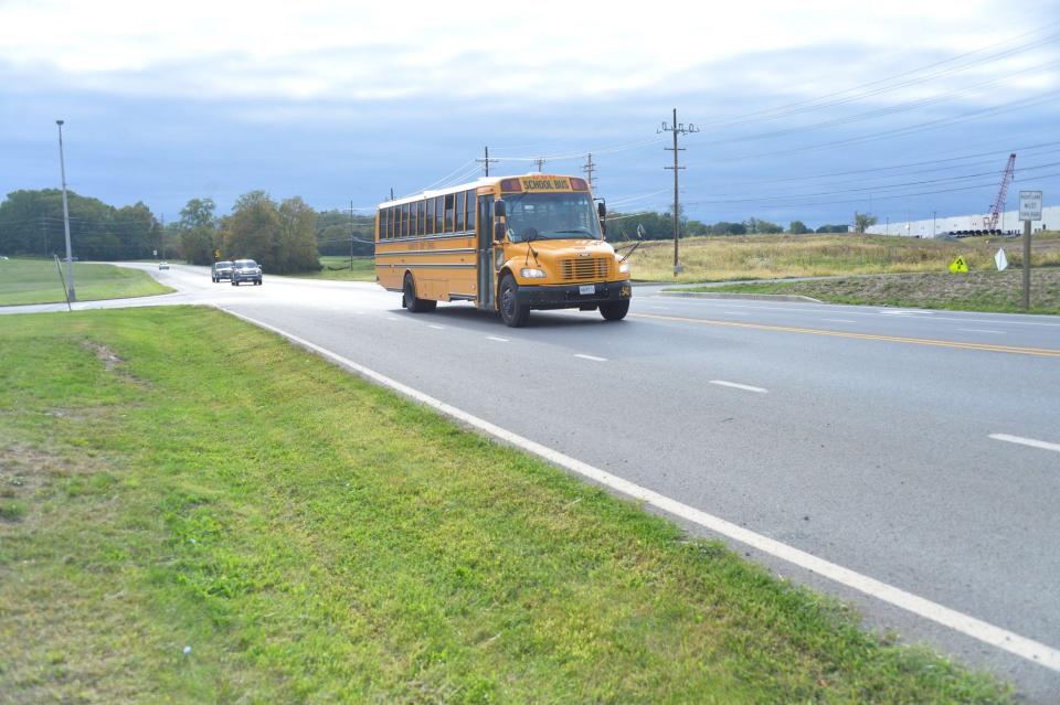 A Washington County Public Schools bus travels along Downsville Pike on Friday near where a traffic signal is proposed at the entrance of WCPS headquarters and a warehouse development being built by Trammell Crow.