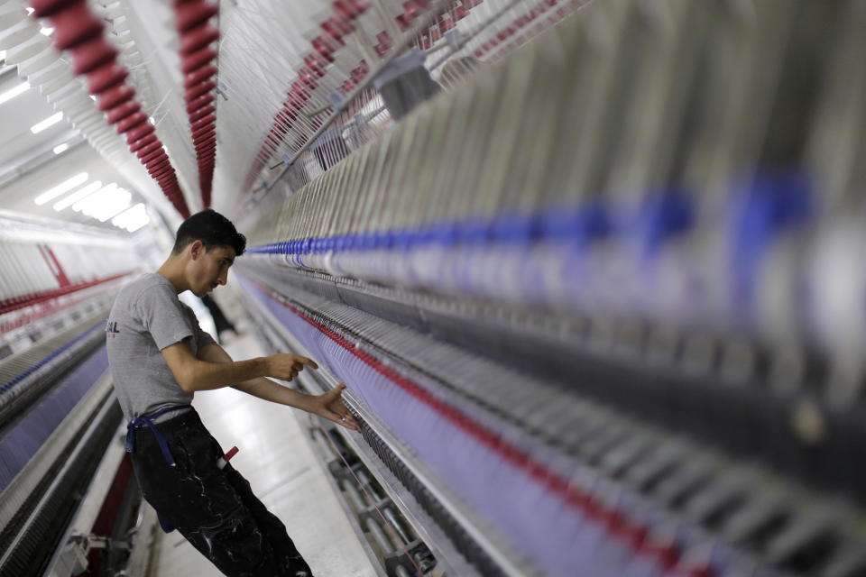 In this Saturday, July 27, 2019 photo, a worker checks the cotton threads at a textile factory in Aleppo, Syria. Syrians say it’s even harder now to make ends meet than it was during the height of their country’s civil war because of intensified U.S and European sanctions. Prices have leaped because of restrictions on oil imports, the value of the currency has plunged in recent months. Most of the country is now below the poverty line, earning less than $100 a month. (AP Photo/Hassan Ammar)