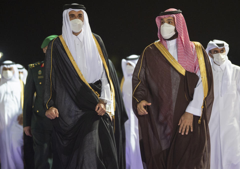 In this photo released by Saudi Royal Palace, Saudi Crown Prince Mohammed bin Salman, right, accompanies Qatar's Emir Sheikh Tamim bin Hamad Al Thani upon his arrival at in the Red Sea city of Jiddah, Saudi Arabia, Monday, May 10, 2021. Qatar's ruling emir is visiting Saudi Arabia for the first time since signing a declaration with other Arab Gulf states to ease a years-long rift and end an embargo that had frayed ties among important U.S. allies and security partners. (Bandar Aljaloud/Saudi Royal Palace via AP)