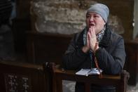 <p>Cette femme prie certainement pour une paix retrouvée dans cette église de Lviv. Depus le début du conflit, ce sont plus de 352 civils ukrainiens qui sont décédés. (DANIEL LEAL/AFP via Getty Images)</p> 
