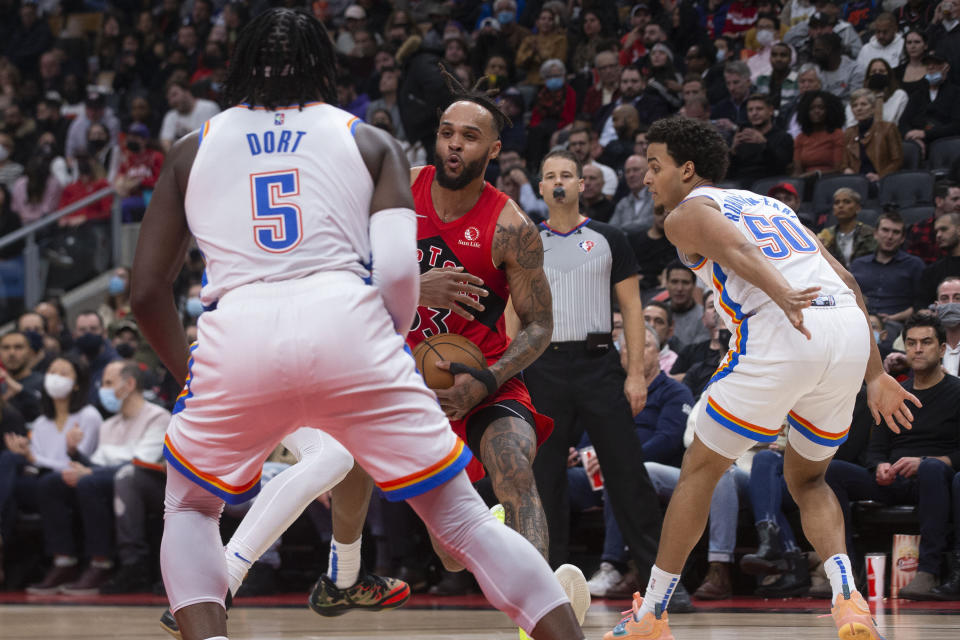 Toronto Raptors' Gary Trent Jr. is defended by Oklahoma City Thunder's Luguentz Dort, left, and Jeremiah Robinson-Earl during the first half of an NBA basketball game Wednesday, Dec. 8, 2021, in Toronto. (Chris Young/The Canadian Press via AP)