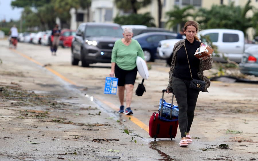 Kings Point residents leave with their belongings after an apparent overnight tornado spawned from Hurricane Ian in Delray Beach, Fla., on Wednesday, Sept. 28, 2022. (Carline Jean/South Florida Sun-Sentinel via AP)